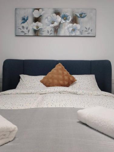 a bed with a brown pillow and flowers on it at Iconic Zuza in Gran Alacant