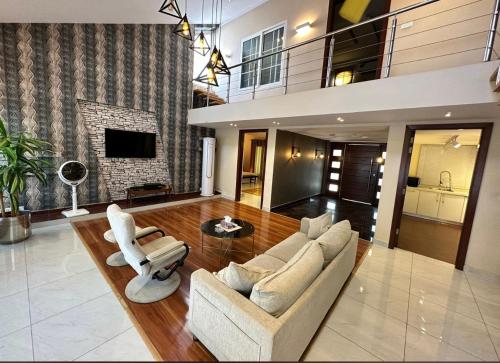 イスラマバードにあるFamily Luxury Lodgesのソファと椅子と暖炉のあるリビングルーム