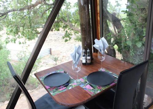 a wooden table with two plates and glasses on it at Tierpoort Barn in Mountain in Tierpoort