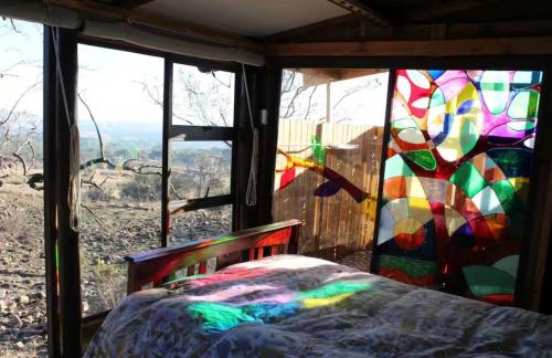 a bedroom with a stained glass window and a bed at Tierpoort Barn in Mountain in Tierpoort