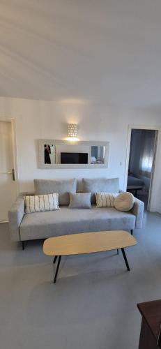 a living room with a couch and a table at Apartamentos Hawaii - Parking y 50 mt del Arenal in Jávea
