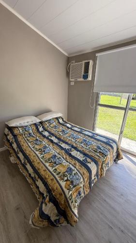 ein Bett in einem Zimmer mit einem Fenster in der Unterkunft Quinta Villa Glori in Villaguay