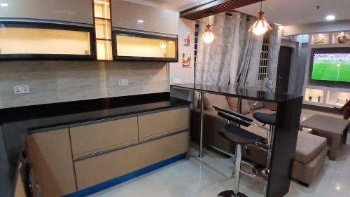 een keuken met een bar en een tv. bij Beatrix Valley, 2 Bedroom Modern Luxury in Tema