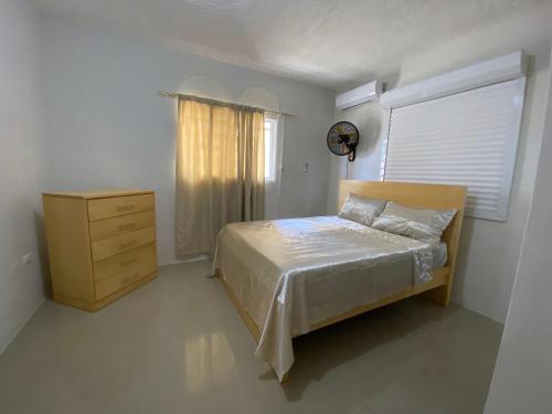 a bedroom with a bed and a dresser and a window at Casa veraniega en samana in Santa Bárbara de Samaná