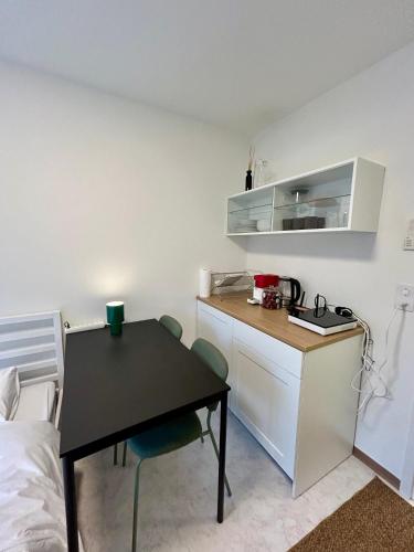 a small kitchen with a black table and a desk at Witikonstrasse 515 in Zürich