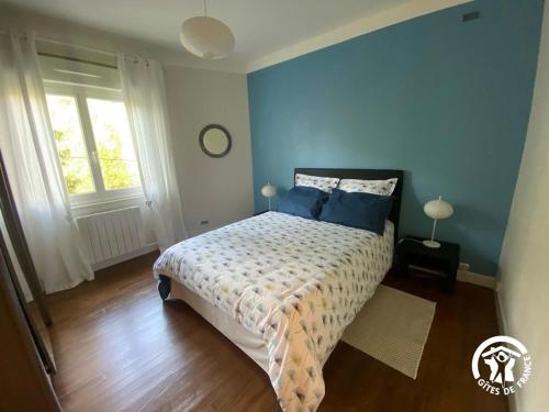 a bedroom with a bed with blue walls at Gîte de la Croix de l'Aveyron in Laguépie