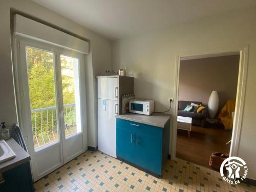 a kitchen with a refrigerator and a counter with a microwave at Gîte de la Croix de l'Aveyron in Laguépie