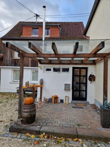 a wooden pergola in front of a house at Haus Fuchsbau, Familienzeit und Fokus im Grünen in Kurtscheid