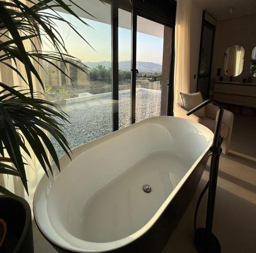 a bath tub in a bathroom with a large window at Casa Troia in Alhaurín de la Torre