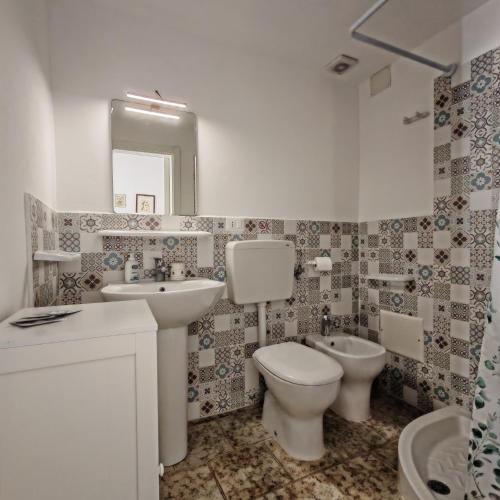 a bathroom with a sink and a toilet and a mirror at Terra di Leuca in Salve