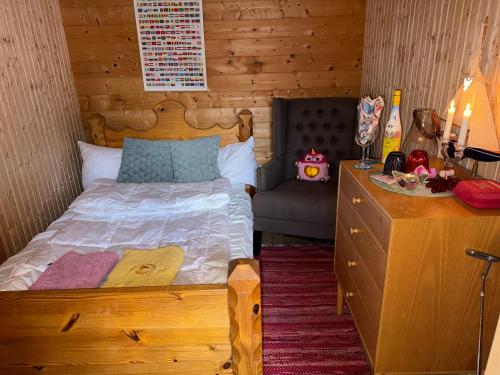 ein Schlafzimmer mit einem Bett und einer Kommode in einem Zimmer in der Unterkunft Glamping in a Bungalow Deluxe by the Forest w Swimmingpool near Golf and the Baltic Sea Beach in Järna