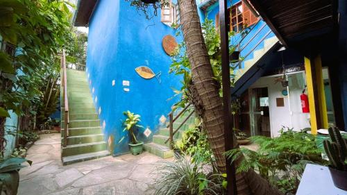 a blue building with stairs and a blue wall at Pousada Mandala - Búzios in Búzios