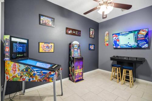 a room with two arcade games and a table at Castaway Cove | Palm Coast in Palm Coast