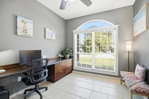 a home office with a desk and a window at Castaway Cove | Palm Coast in Palm Coast