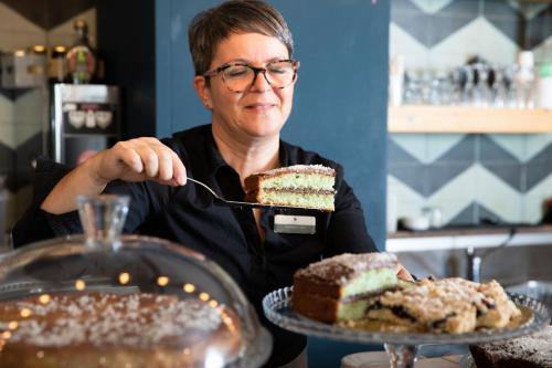 a woman eating a piece of cake with a fork at Ruffini Boutique Rooms in Ascoli Piceno