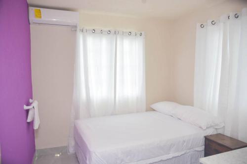 ブリッジタウンにあるGrateful 3bd B by ZenBreakのベッドが2つと窓がある白い部屋