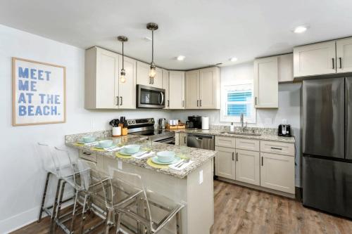 a kitchen with white cabinets and a large island with bar stools at Downtown Retreat, 5BR Game Room & Pet Friendly in Wilmington
