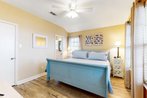 a bedroom with a blue bed and a ceiling fan at Prime Gulf Views Large Deck Pet Paradise in Bolivar Peninsula