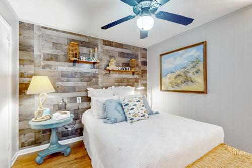 a bedroom with a bed and a ceiling fan at Stunning Beachfront Beach Access Dog Haven in Hercules Offshore Heliport