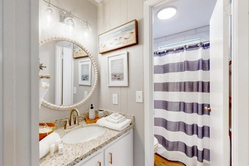 a bathroom with a sink and a mirror at Stunning Beachfront Beach Access Dog Haven in Hercules Offshore Heliport