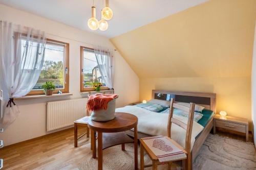 a bedroom with a bed and a table with a chair at Haus im Grünen in Oederan