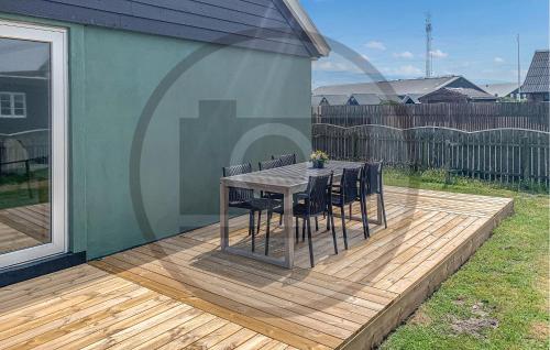 een houten terras met een tafel en stoelen erop bij Lovely Home In Thyborøn With Wifi in Thyborøn