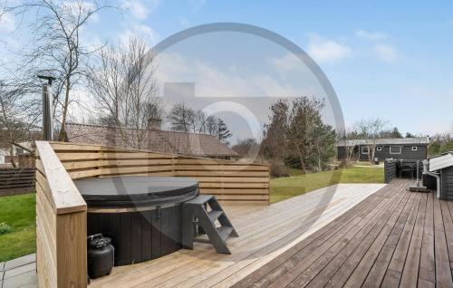 een houten terras met een tafel en een bank erop bij Lovely Home In Thyborøn With Wifi in Thyborøn