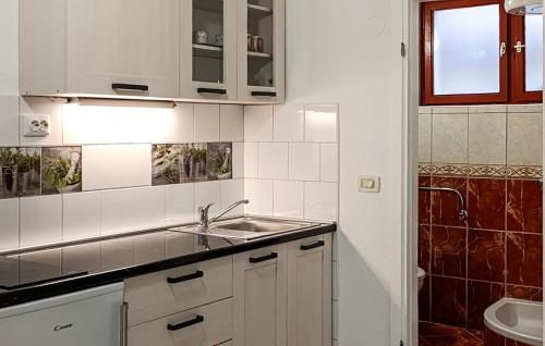 Nice Apartment In Podgora With Wifi في Kržanići: مطبخ أبيض مع حوض ومرحاض