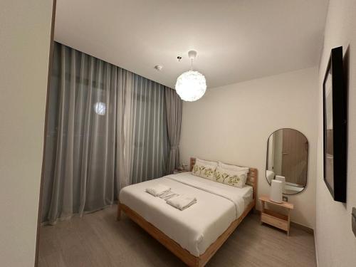une chambre avec un grand lit et un miroir dans l'établissement Stunning 1 Bed in Meydan, à Dubaï