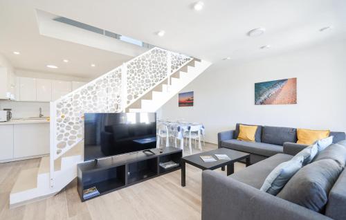 Lovely Home In Privlaka في Glavan: غرفة معيشة مع أريكة وتلفزيون بشاشة مسطحة