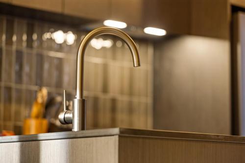 a sink with a faucet in a bathroom at Luxury Ka Tiritiri Villa Queenstown in Queenstown Airport
