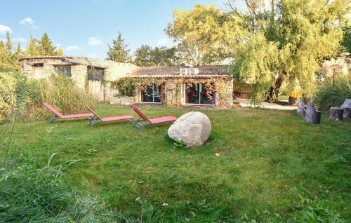 ein Hof mit zwei Parkbänken und einem Felsen in der Unterkunft Stunning Home In Jonquières in Jonquières