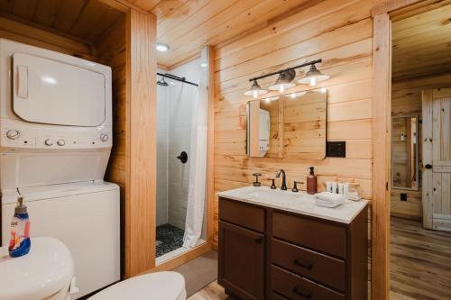 a bathroom with a sink and a toilet in a log cabin at The Lazy Maple in Red River Gorge in Rogers