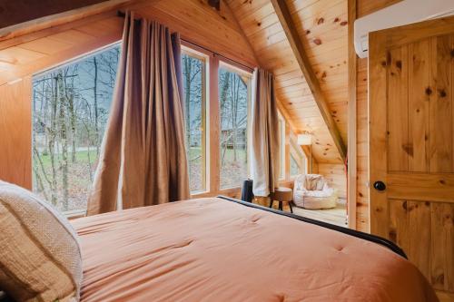 a bedroom in a tree house with a large window at The Lazy Maple in Red River Gorge in Rogers