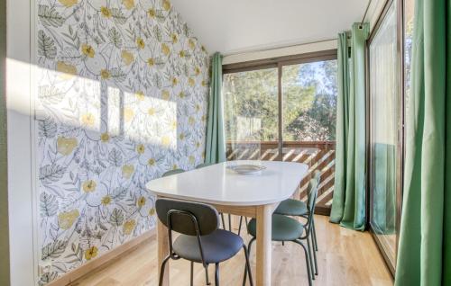 ein Esszimmer mit Tisch und Stühlen und einem Fenster in der Unterkunft Charmant Appartement in Saint-Georges-de-Didonne