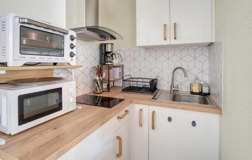 eine Küche mit Mikrowelle und Spüle in der Unterkunft Charmant Appartement in Saint-Georges-de-Didonne