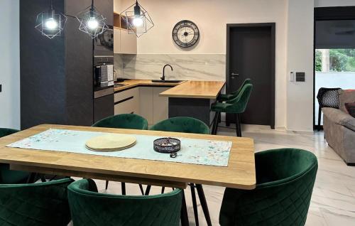 KaštelinaにあるBeautiful Home In Virのキッチン、ダイニングルーム(テーブル、緑の椅子付)