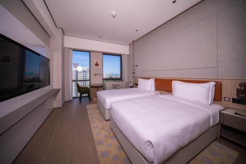 a hotel room with two beds and a flat screen tv at Holiday Inn Beijing Daxing Centre by IHG in Beijing