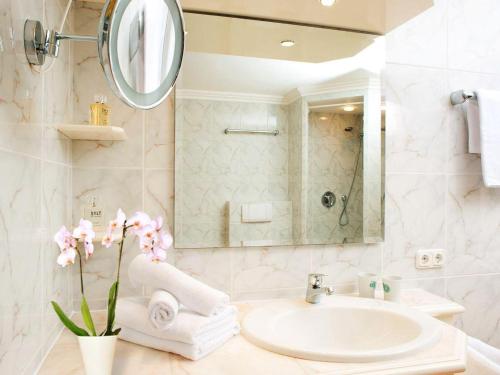 Un baño blanco con lavabo y espejo. en Enenhoog-Flugente, en Kampen