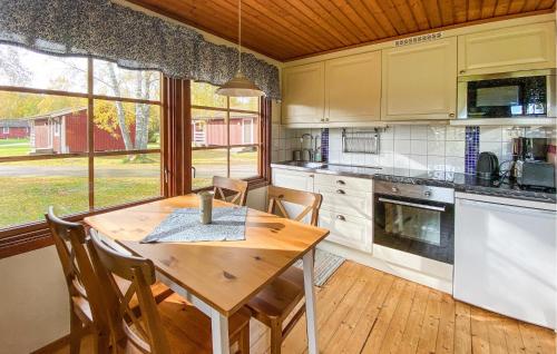 2 Bedroom Stunning Home In Byxelkrok في بيكسلكروك: مطبخ مع طاولة خشبية وطاولة وكراسي