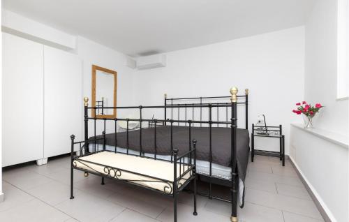 a black bed in a white room with flowers at Nice Apartment In Mali Losinj With Wifi in Cunski