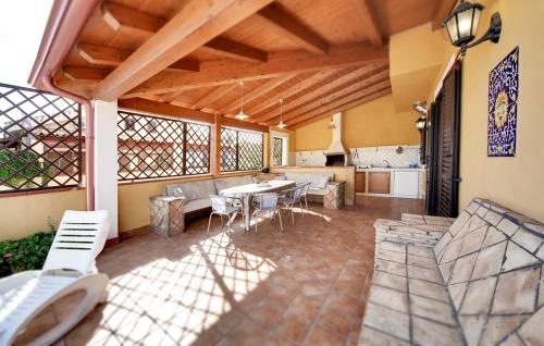 eine Terrasse mit Tisch und Stühlen und eine Küche in der Unterkunft Beautiful Home In Ragusa in Plaia Grande