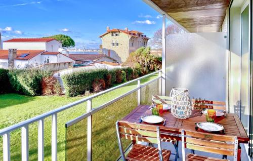 a table on a balcony with a view of a house at Charmant Appartement Vue Mer in Saint-Georges-de-Didonne