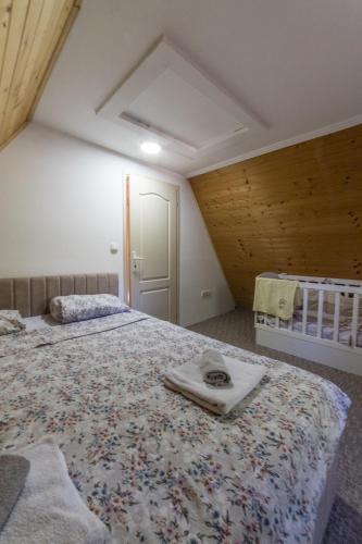 a bedroom with two beds and a crib at Vila Dom Drina Zatvoreni Bazen in Bajina Bašta