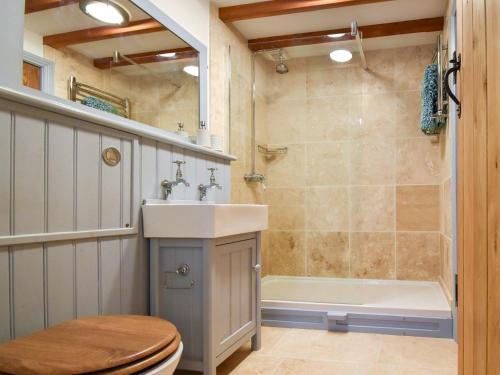 a bathroom with a sink and a toilet and a tub at 2 Bed in Bamburgh 36344 in Kyloe