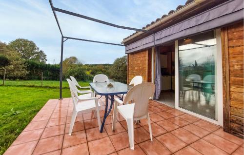 eine Terrasse mit weißen Stühlen und einem Tisch auf einer Terrasse in der Unterkunft 2 Bedroom Cozy Home In Eyraud-Crempse-Maurens in La Ressegue
