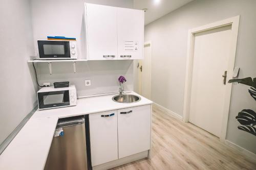 ロスピタレート・デ・リョブレガートにあるHotel Fira Boutique Barcelonaのシンクと電子レンジのある小さなキッチン