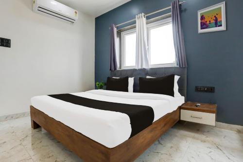 a bedroom with a large bed with a blue wall at HOTEL O ANUSHTHAN in Jabalpur