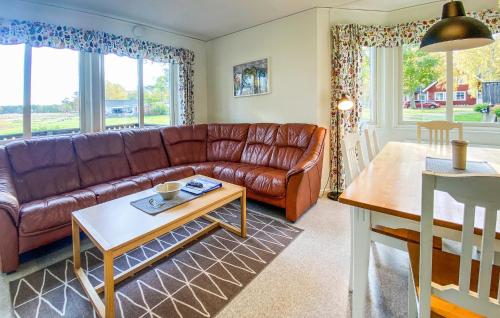 ein Wohnzimmer mit einem braunen Ledersofa und einem Tisch in der Unterkunft Lovely Home In Byxelkrok With Wifi in Byxelkrok
