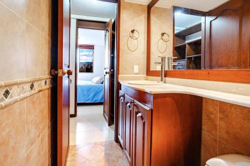 a bathroom with a sink and a mirror and a bed at City views Air-conditioning Heated pool in Envigado
